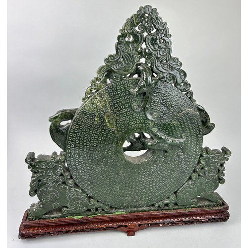 243 - A LARGE CHINESE GREEN STONE SCULPTURE,

40cm x 40cm 

Mounted on a wooden stand.