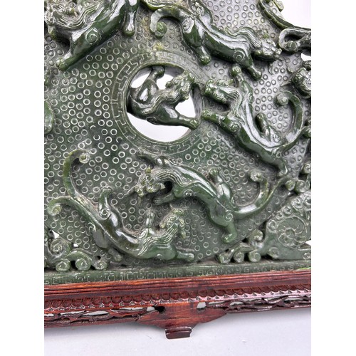 243 - A LARGE CHINESE GREEN STONE SCULPTURE,

40cm x 40cm 

Mounted on a wooden stand.