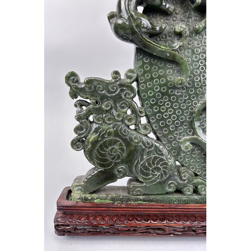 243 - A LARGE CHINESE GREEN STONE SCULPTURE,

40cm x 40cm 

Mounted on a wooden stand.