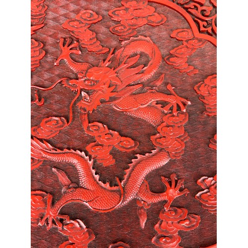 254 - A CHINESE RED LACQUERED CINNABAR BOX ALONG WITH A SIMILAR CIRCULAR PLATE (2), 

Box 39cm x 29cm 

Pl... 