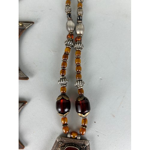 187 - A MOROCCAN TUAREG 'VAIL WEIGHT' ALONG WITH A CARNELIAN AND WHITE METAL NECKLACE, 

Longest 36cm