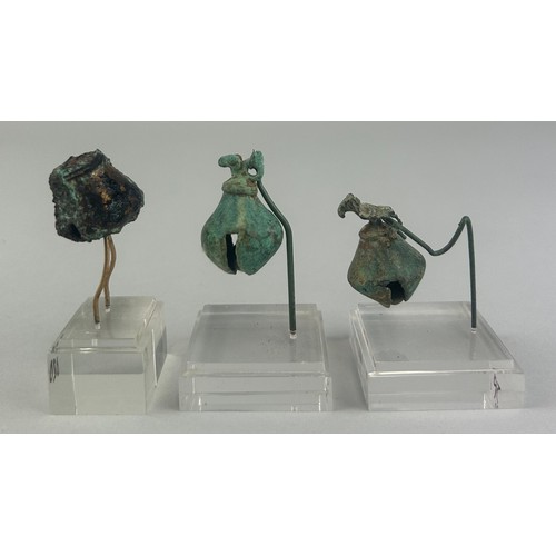 112 - A GROUP OF THREE PRE-COLUMBIAN TUMBAGA BELL ORNAMENTS: 

Largest 3cm x 2cm 

Two with perspex stands... 