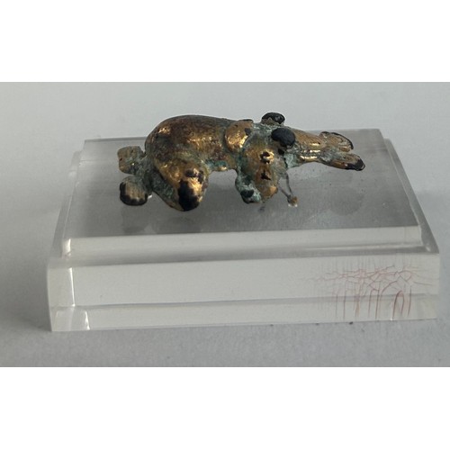 106 - A PRE-COLUMBIAN TUMBAGA FROG ORNAMENT, 

3.3cm x 2cm 

Mounted on perspex stand. 

4.5cm x 3cm