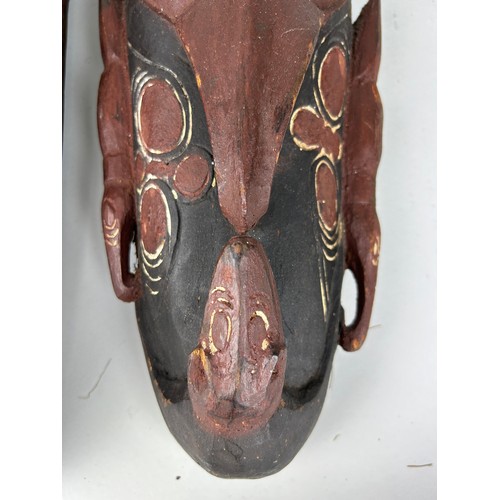 200 - TWO CARVED OCEANIC PAINTED WOODEN MASKS WITH SHELL DETAIL, 

Largest 55cm L