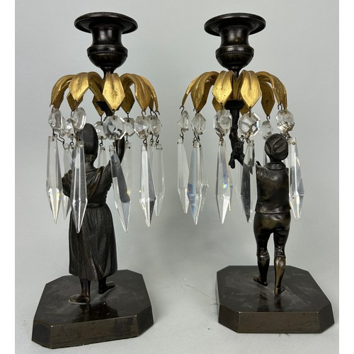 28 - A PAIR OF BRONZE CANDLESTICKS DEPICTING MALE AND FEMALE FIGURES HOLDING WITH PALM LEAVES AND GLASS D... 