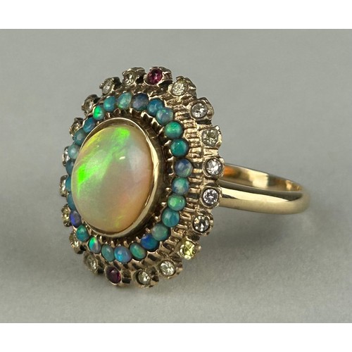 170 - A GOLD RING SET WITH A CENTRAL OPAL SURROUNDED BY DIAMONDS, RUBIES AND SMALL OPALS, 

Weight: 6.7gms