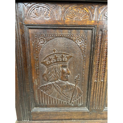 469B - AN OAK CHEST IN THE ARTS AND CRAFTS MANNER WITH TWO ROYAL HEADS FLANKING A CENTRAL FLOWER, 

126cm x... 