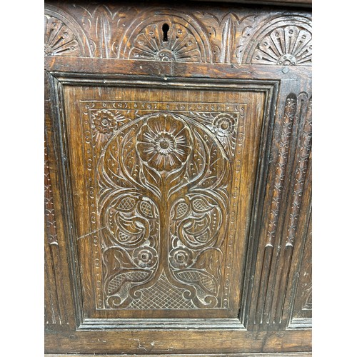 469B - AN OAK CHEST IN THE ARTS AND CRAFTS MANNER WITH TWO ROYAL HEADS FLANKING A CENTRAL FLOWER, 

126cm x... 