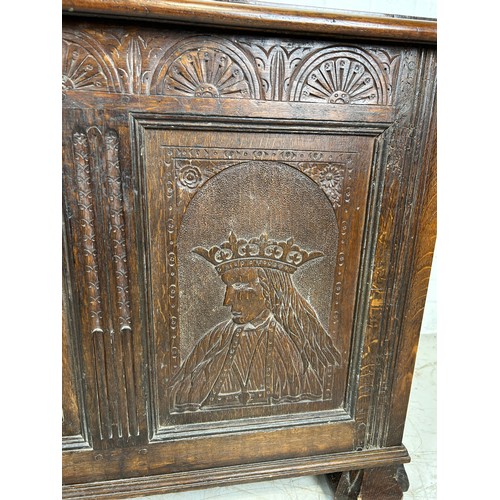 469B - AN OAK CHEST IN THE ARTS AND CRAFTS MANNER WITH TWO ROYAL HEADS FLANKING A CENTRAL FLOWER, 

126cm x... 