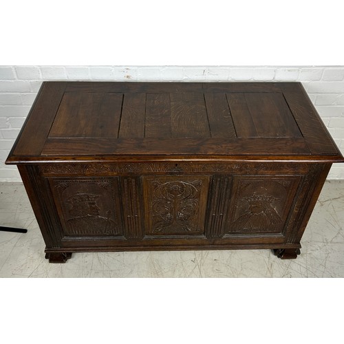 469B - AN OAK CHEST IN THE ARTS AND CRAFTS MANNER WITH TWO ROYAL HEADS FLANKING A CENTRAL FLOWER, 

126cm x... 