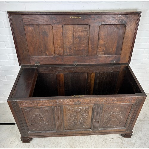 469B - AN OAK CHEST IN THE ARTS AND CRAFTS MANNER WITH TWO ROYAL HEADS FLANKING A CENTRAL FLOWER, 

126cm x... 