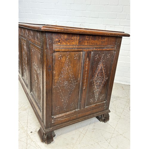 469B - AN OAK CHEST IN THE ARTS AND CRAFTS MANNER WITH TWO ROYAL HEADS FLANKING A CENTRAL FLOWER, 

126cm x... 