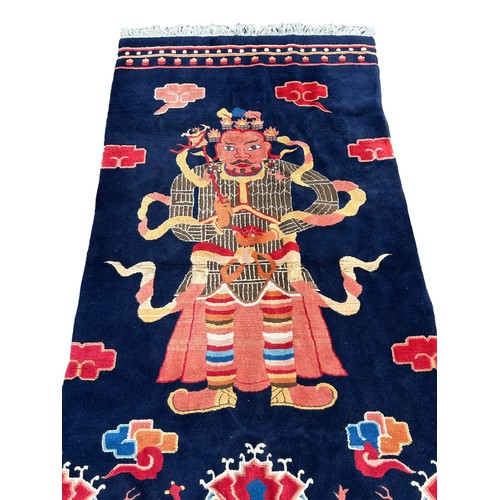 897 - A LARGE CHINESE OR TIBETAN CARPET DEPICTING A WARRIOR, 

250cm x 125cm