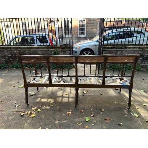 47 - A REGENCY PERIOD GREEN PAINTED FAUX BAMBOO SETTLE WITH CANEED BACK AND SEAT, 

180cm x 87cm x 67cm