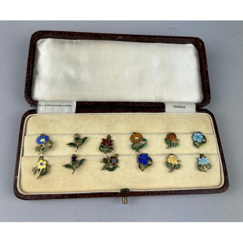 128 - A CASED SET OF FLORAL SILVER GILT AND ENAMEL LAPEL PINS MADE IN ENGLAND, 

Case marked 'Zarger'.