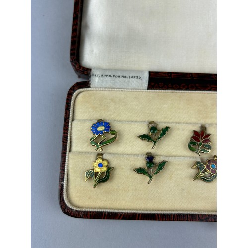 128 - A CASED SET OF FLORAL SILVER GILT AND ENAMEL LAPEL PINS MADE IN ENGLAND, 

Case marked 'Zarger'.