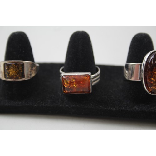 200 - A COLLECTION OF SILVER AND AMBER RINGS INCLUDING MODERNIST,

Weight: 27gms