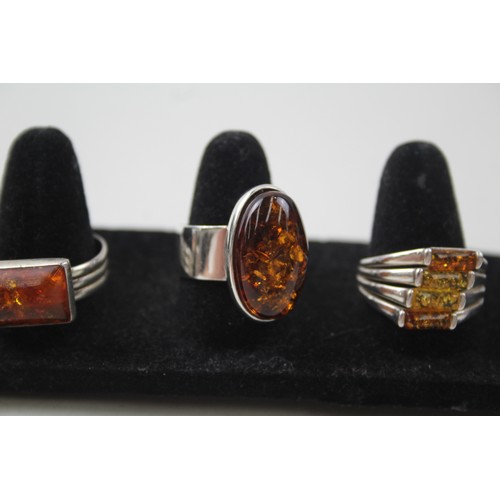 200 - A COLLECTION OF SILVER AND AMBER RINGS INCLUDING MODERNIST,

Weight: 27gms