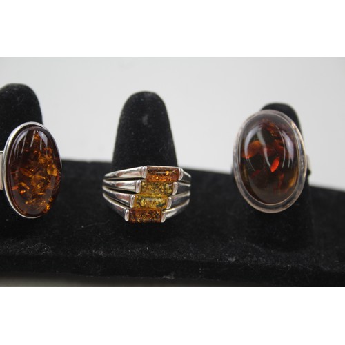 200 - A COLLECTION OF SILVER AND AMBER RINGS INCLUDING MODERNIST,

Weight: 27gms