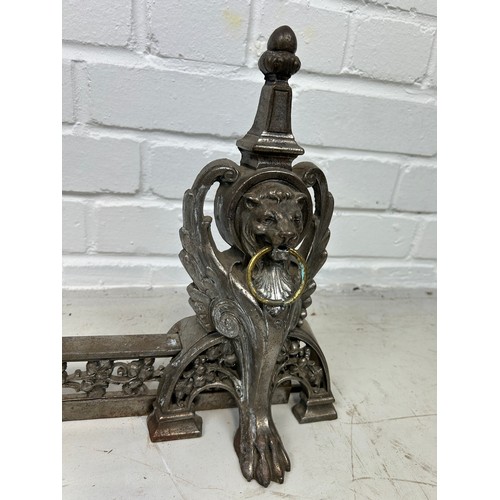 779 - AN ANTIQUE METAL FIRE FENDER DECORATED WITH WINGED LIONS HEAD MASKS AND PAW FEET, 

98cm x 31cm