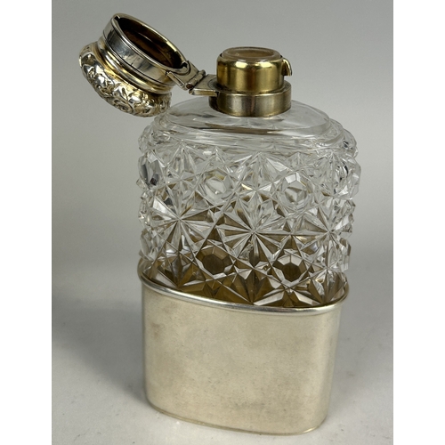 21 - A VICTORIAN SILVER MOUNTED AND CRYSTAL HIP FLASK WITH FOLIATE DESIGN EMBOSSED TOP 13.5cm H