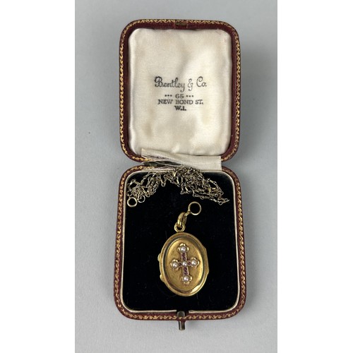 3 - AN ANTIQUE OVAL GOLD LOCKET WITH HALF-PEARL SET CROSS TO CENTRE 1.5cm high, together with a gold tra... 