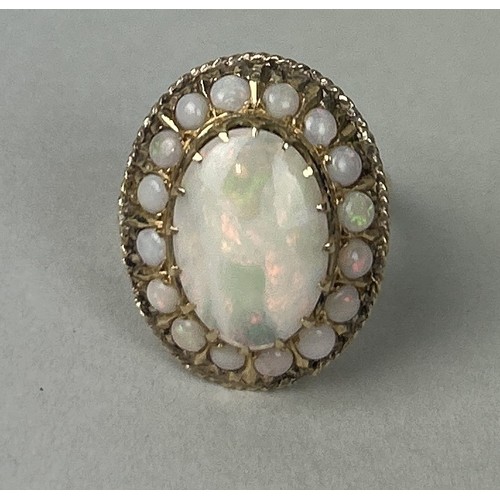 37 - A 14CT GOLD RING SET WITH A LARGE CENTRAL OPAL SURROUNDED BY SMALLER OPALS Weight: 7.3gms