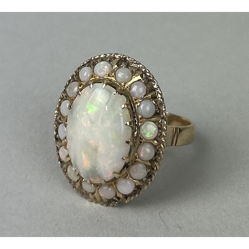 37 - A 14CT GOLD RING SET WITH A LARGE CENTRAL OPAL SURROUNDED BY SMALLER OPALS Weight: 7.3gms