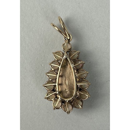 33 - AN 18CT GOLD PENDANT SET WITH A PEAR CUT OPAL SURROUNDED BY SMALL OPALS Weight: 5.4gms