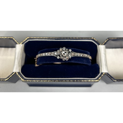 63 - AN 18CT GOLD AND ROSE DIAMOND BANGLE 6.5cm D Weight: 12.5gms The diamonds set in silver. With box.