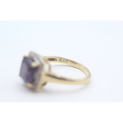 108 - A 9CT GOLD AMETHYST SINGLE STONE RING WITH DIAMOND SURROUND Weight: 3.5gms