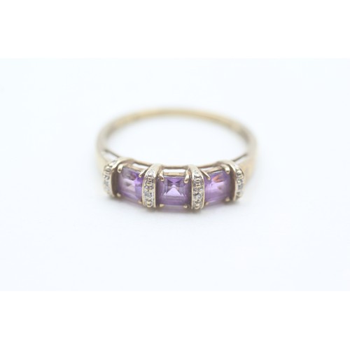 128 - A 9CT GOLD AMETHYST THREE STONE RING WITH DIAMOND SPACERS Weight: 2.6gms