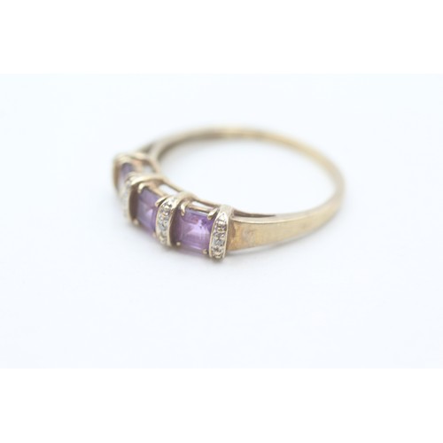 128 - A 9CT GOLD AMETHYST THREE STONE RING WITH DIAMOND SPACERS Weight: 2.6gms