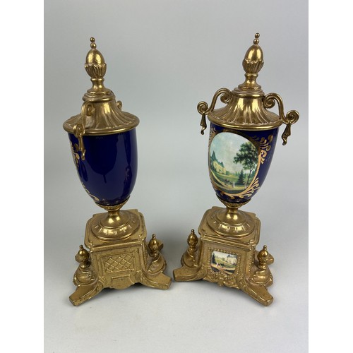 1075E - A PAIR OF FRENCH CERAMIC AND GILT METAL URNS PAINTED WITH LANDSCAPE SCENES