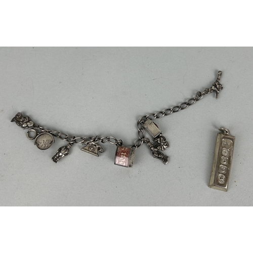 186 - A SILVER CHARM BRACELET ALONG WITH A SILVER INGOT
Total weight: 57.9gms