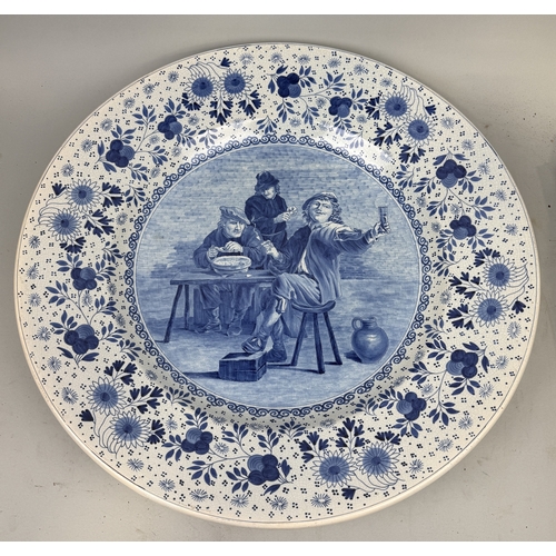 296 - A VERY LARGE DUTCH DELFT BLUE AND WHITE CHARGER CIRCA 1900
Painted with a Dutch Old master tavern sc... 