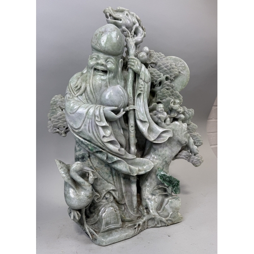 151 - A CHINESE JADE OR JADEITE SCULPTURE DEPICTING THE LUOHAN WITH A DRAGON STAFF, CHILDREN, CRANES AND F... 