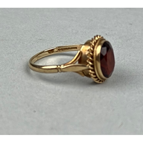 330B - A 9CT GOLD RING SET WITH AN OVAL RED STONE

Weight: 2.8gms