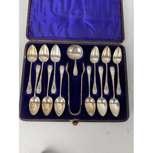 45 - A BOX OF SILVER SPOONS AND TONGS WITH LIONS HEAD HANDLES ALONG WITH SILVER SPOONS, KNIVES (STAINLESS... 
