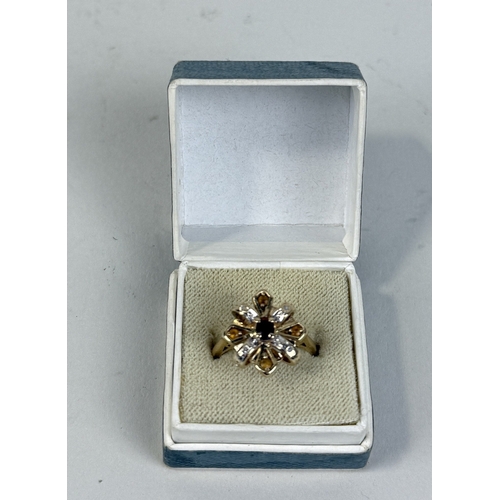 36 - A 14CT GOLD RING WITH RUBY IN CENTRE WITH DIAMONDS AND TOPAZ SURROUNDING