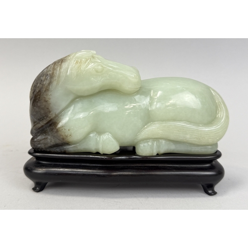 279 - A CHINESE JADE SCULPTURE OF A RECUMBENT HORSE
Jade: 17cm L
With associated wooden stand... 