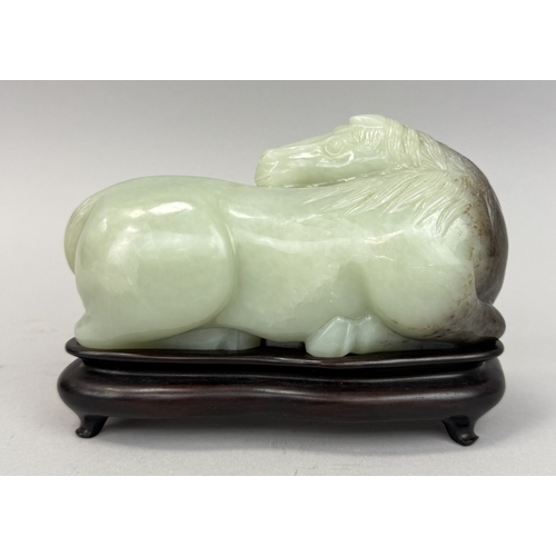 279 - A CHINESE JADE SCULPTURE OF A RECUMBENT HORSE
Jade: 17cm L
With associated wooden stand... 