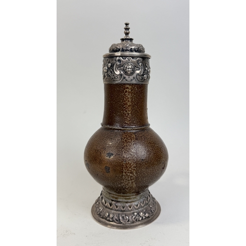 64 - A 17TH CENTURY SALT GLAZED BELLARMINE JUG WITH SILVER MOUNTS AND BASE
25cm HProvenance: Appleby Cast... 