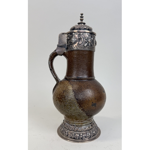 64 - A 17TH CENTURY SALT GLAZED BELLARMINE JUG WITH SILVER MOUNTS AND BASE
25cm HProvenance: Appleby Cast... 
