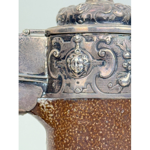64 - A 17TH CENTURY SALT GLAZED BELLARMINE JUG WITH SILVER MOUNTS AND BASE
25cm HProvenance: Appleby Cast... 