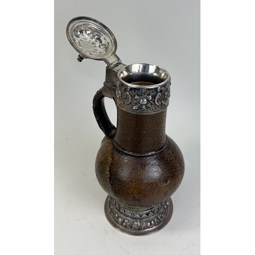64 - A 17TH CENTURY SALT GLAZED BELLARMINE JUG WITH SILVER MOUNTS AND BASE
25cm HProvenance: Appleby Cast... 