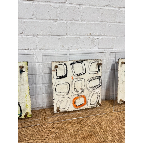 477 - THREE PAINTED METALLIC ARTWORKS MOUNTED IN PERSPEX FRAMES
40cm x 38cm each.
Signed indistinctly to v... 