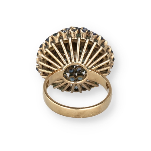 19 - AN 18 CARAT GOLD BOMBÉ RING, CLAW SET WITH FIVE ROWS OF SAPPHIRES
The central stone in a ropetwist s... 