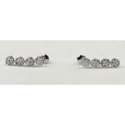 31 - AN 18CT WHITE GOLD AND DIAMOND FLORAL CLUSTER BRACELET AND EARRING SUITE
Approximately 9.48ct total ... 