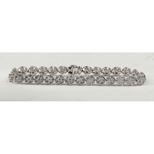 31 - AN 18CT WHITE GOLD AND DIAMOND FLORAL CLUSTER BRACELET AND EARRING SUITE
Approximately 9.48ct total ... 